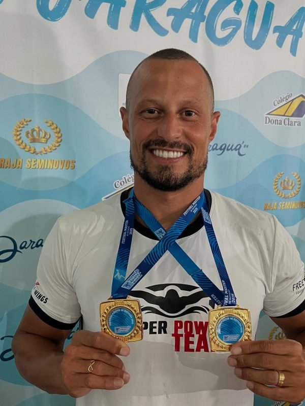 Osmar Lanes com medalhas que conquistou em uma competição.